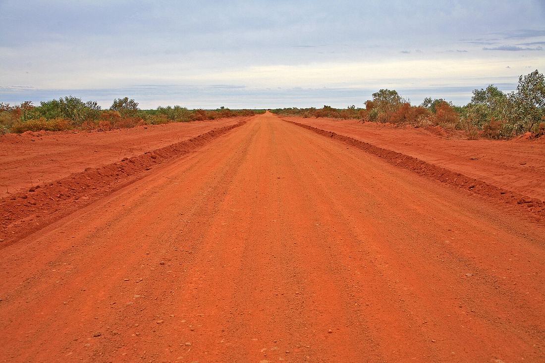 A red dirt road running through the Australian outback